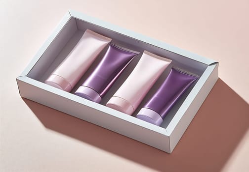 Four elegantly packaged skincare tubes arranged in a box, showcasing a variety of colors and designs on a soft pastel background.