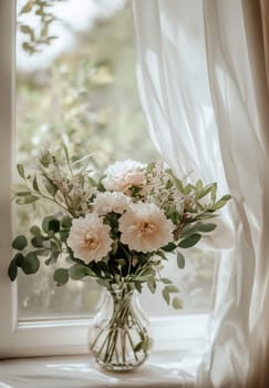 A beautiful bouquet of fresh flowers sits in a clear vase on a windowsill, basking in soft natural light.