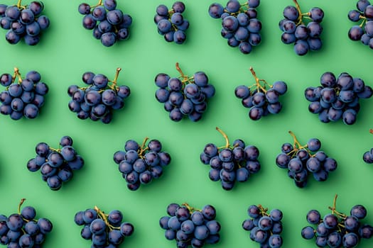 Dark grapes are neatly arranged on a vibrant green surface, showcasing their rich color and freshness for a visually appealing display.