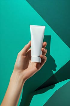 A hand displays a white skincare tube against a textured teal backdrop, showcasing beauty and simplicity in design.