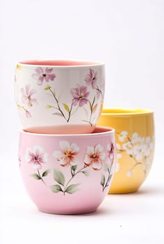 Three vibrant tea cups with delicate floral designs are stacked, showcasing pastel colors and elegant artistry perfect for serving tea.