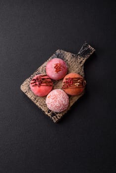 Delicious colorful asian mochi sweets with rice dough shell and fruit filling on dark concrete background