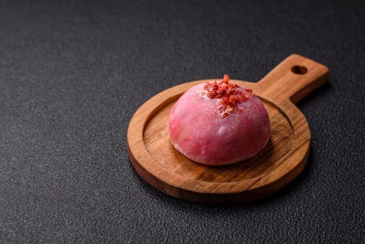 Delicious colorful asian mochi sweets with rice dough shell and fruit filling on dark concrete background