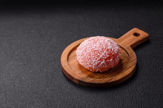 Delicious colorful asian mochi sweets with rice dough shell and fruit filling on dark concrete background