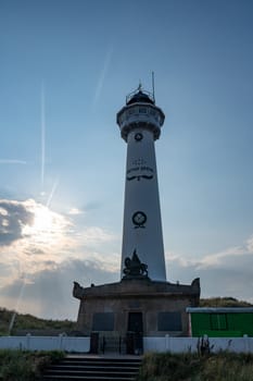 The approx. 28 m high white lighthouse J.C.J. van Speijk in Egmond aan Zee, North Holland, Netherlands at sunset