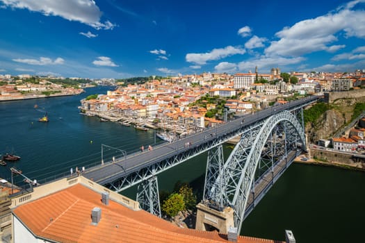 View of Porto city and Douro river with moored sailing ship and Dom Luis bridge I from famous tourist viewpoint Miradouro da Serra do Pilar on sunset. Porto, Vila Nova de Gaia, Portugal