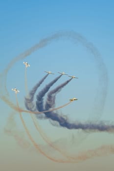 Stunt aerobatic planes performing stunts in blue sky with smoke trail. Concept of teamwork, collaboration, coordination, trust, precision, difficulty, challenge, speed, synergy