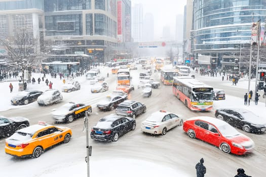 Vehicles struggle to navigate through a snow-covered intersection amidst a blizzard. Pedestrians cautiously cross the road.