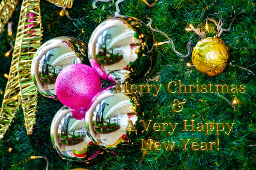 Golden Merry Christmas and Happy New Year Wishes text with Christmas ball and pine tree background. Christmas celebration concept.
