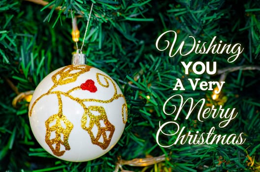 Wishing you a very Merry Christmas text with white Christmas ball background. Christmas celebration concept.