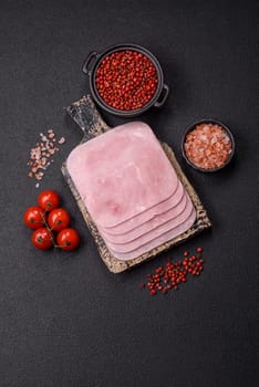 Boiled ham cut into square slices with sorrel and spices on a dark concrete background