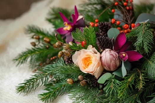 A beautiful arrangement of fresh flowers and greenery with ornaments and berries perfect for celebrating the Christmas season.