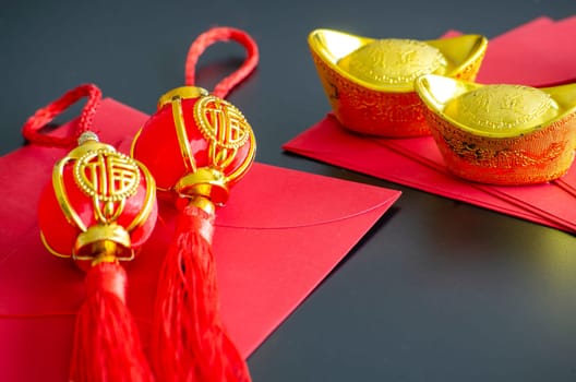 Chinese New Year decoration with golden ingots and Chinese New Year balls on red packets.