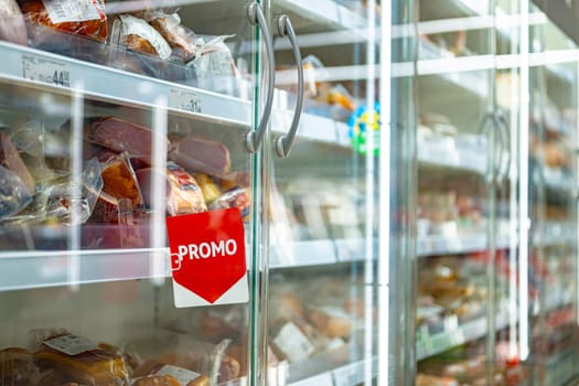 Promo sign at a commercial refrigerator in a supermarket.