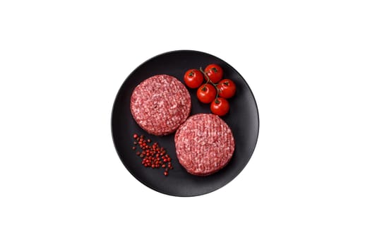 Fresh raw ground beef burger patty with salt and spices on a white background