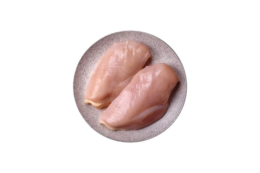 Pieces of raw chicken or turkey fillet with salt, spices and herbs on a white background