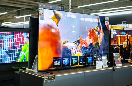 POZNAN, POL - DEC 5, 2024: Modern flat-screen TV sets put up for sale in an electronics store