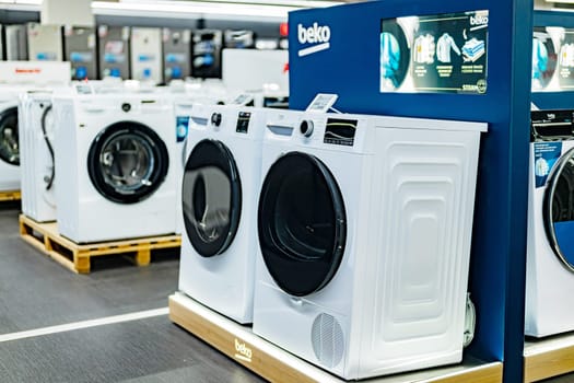 POZNAN, POL - DEC 5, 2024: Front-loader washing machines by Beko put up for sale in a household goods store