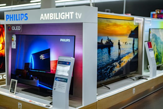 POZNAN, POL - DEC 5, 2024: Modern flat-screen TV sets put up for sale in an electronics store