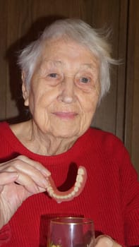 flexible nylon denture on senior female hands. Removable dentures flexible, devoid of nylon, hypoallergenic exempt from monomer