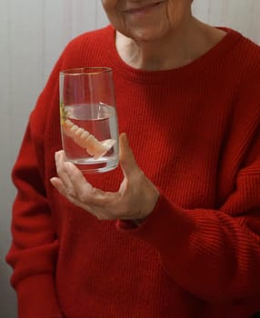 flexible nylon denture on senior female hands. Removable dentures flexible, devoid of nylon, hypoallergenic exempt from monomer