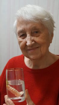 flexible nylon denture on senior female hands. Removable dentures flexible, devoid of nylon, hypoallergenic exempt from monomer