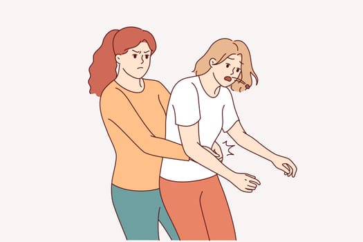 Heimlich technique is demonstrated by woman saving friend who was choking and pressing on stomach to restore breathing. Girl provides first aid and uses heimlich technique to avoid harm to health.