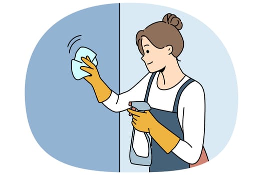 Housewife woman cleaning apartment, wiping wall or glass using antibacterial spray, dressed in apron and gloves. Happy girl works as maid in motel and cleaning preparing room for arrival of guests