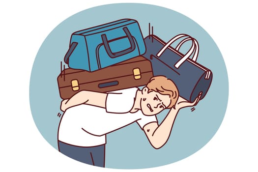 Dissatisfied man with heavy suitcases is moving or relocating to new city. Guy in casual clothes bends over putting suitcases on back and looks at screen in need of help from loader