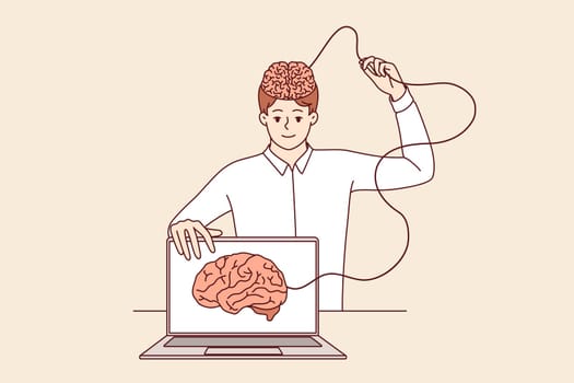 Man develops artificial intelligence and transfers own brain to internet, standing near laptop. Process of learning ai technologies to create innovative software with artificial intelligence