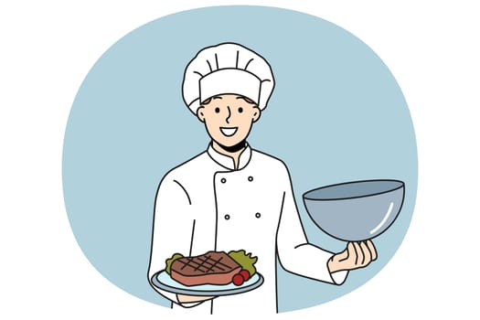 Man chef holds tray with beef steak and vegetables, inviting you to visit restaurant of classic european cuisine. Guy in cook uniform demonstrates grilled pork steak at popular steakhouse.