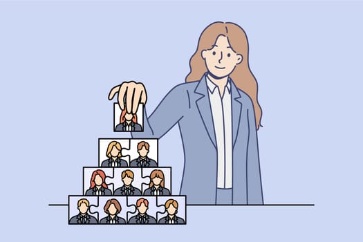Woman recruiter is engaged in team building and creating corporate governance structure. Team building process from ceo of company, putting puzzles from employee portraits into pyramid