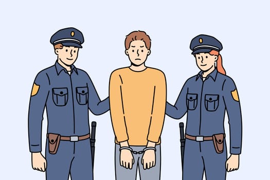 Two cops in police uniforms detained and handcuffed criminal for breaking law or disrespecting detectives. Brave cops fight crime to ensure safety of ordinary city residents who need protection