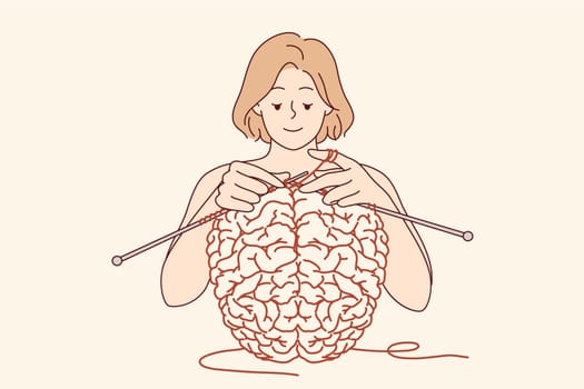 Woman creates brain using knitting as metaphor for psychological therapy and mental health care. Girl works on developing brain and memory or intelligence, helping to achieve mental stability