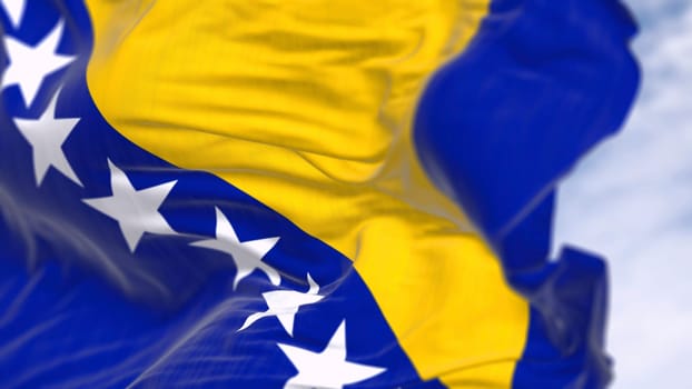Close-up of Bosnia and Herzegovina national flag waving in the wind. Blue field with yellow triangle and white stars. 3d illustration render. Fluttering textile. Selective focus