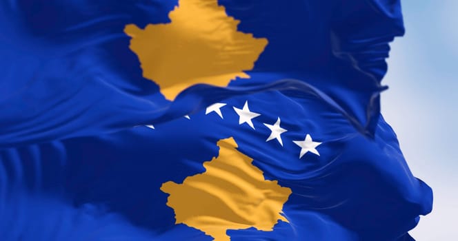 Close-up of Kosovo national flags waving on a clear day. Six white stars above a golden map of Kosovo in a blue field. 3d illustration render. Rippling textured fabric.