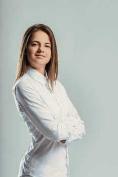 Portrait of a young businesswoman posing with crossed arms and smiling, looking confident and professional, expressing positivity and determination