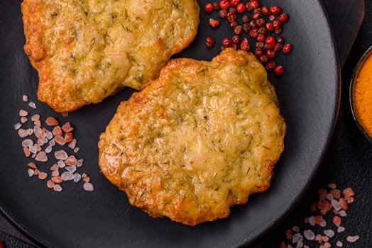 Delicious fried pork or chicken chops breaded with salt and spices on a dark concrete background