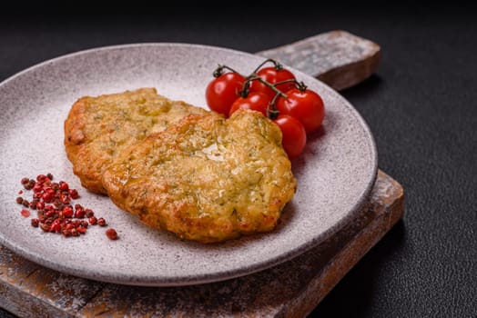 Delicious fried pork or chicken chops breaded with salt and spices on a dark concrete background