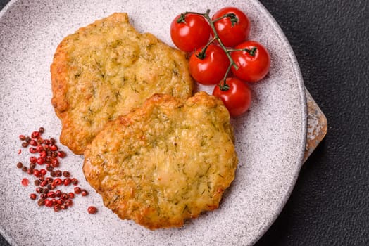 Delicious fried pork or chicken chops breaded with salt and spices on a dark concrete background