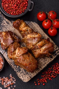 Delicious grilled chicken, turkey or pork skewers with salt, spices and herbs on a fire on a dark concrete background