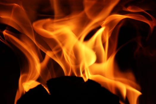 Flames from a fire in front of a black background