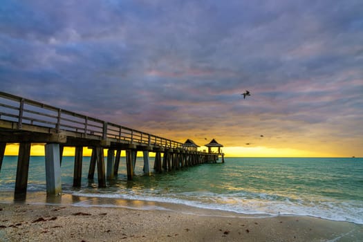 Pier and the beach in Naples, Florida, at sunset