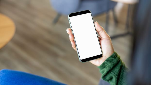 Woman hand holding smartphone with white empty screen in hand, Smartphone mockup for online shopping, Booking and banking concept, Online education or online business with copy space.