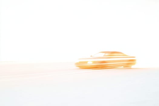 A car is driving on a snowy road. The car is blurry and the road is white