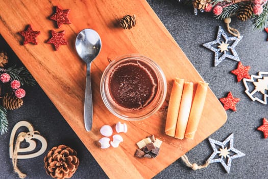 Traditional hot chocolate with marshmallows and chocolate chips in a Christmas decoration in studio