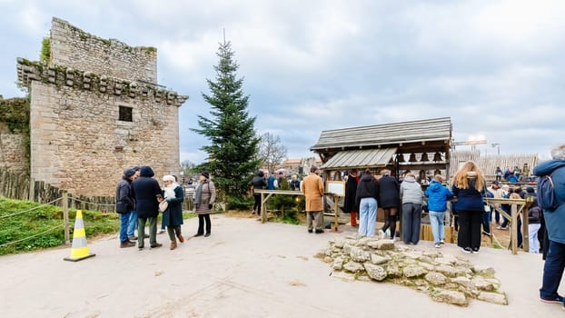 Tiffauges, Vendee, France - December 8, 2024: Street atmosphere and architecture at the Christmas Market at Tiffauges Castle on a gray winter day