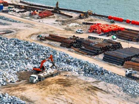 Construction progress on shipping port terminal through land reclamation. Global trade development, infrastructure engineering, and marine environmental sustainability efforts. Maritime infrastructure