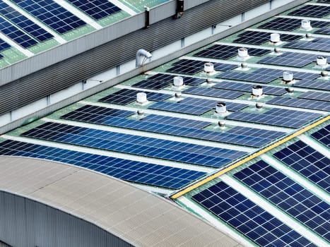 Rooftop solar panels on an industrial plant building. Clean and renewable power solutions, green energy innovation, and sustainable commercial electricity generation. Sustainable manufacturing.