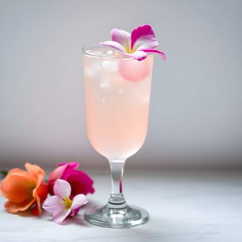 A sophisticated lychee and rose mocktail, adorned with delicate flower garnishes, exudes elegance against a minimalist backdrop.